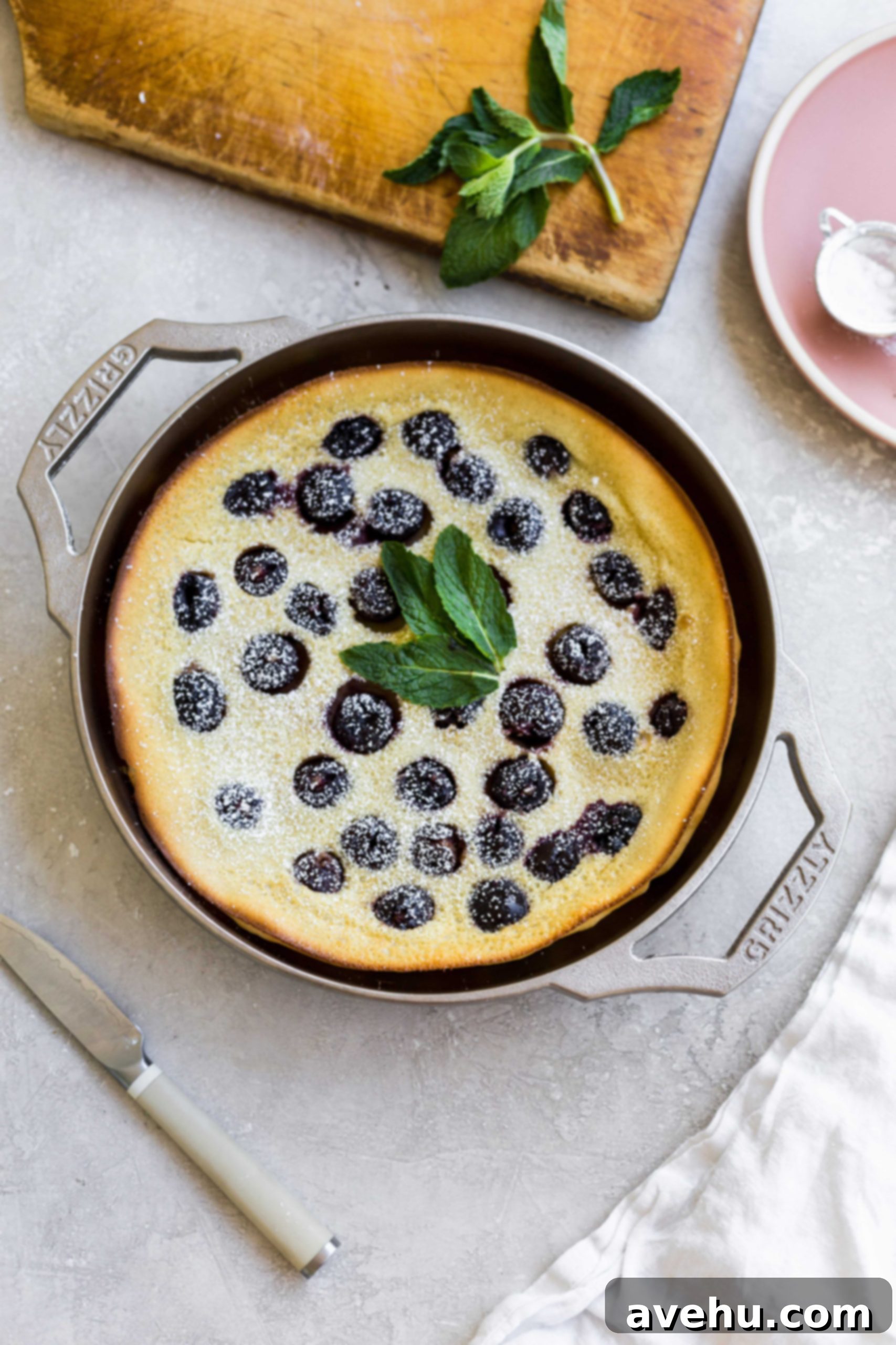 Bourbon Cherry Clafoutis 3 A cherry clafoutis made in a GRIZZLY nickel plated cast iron pan on a gray background.
