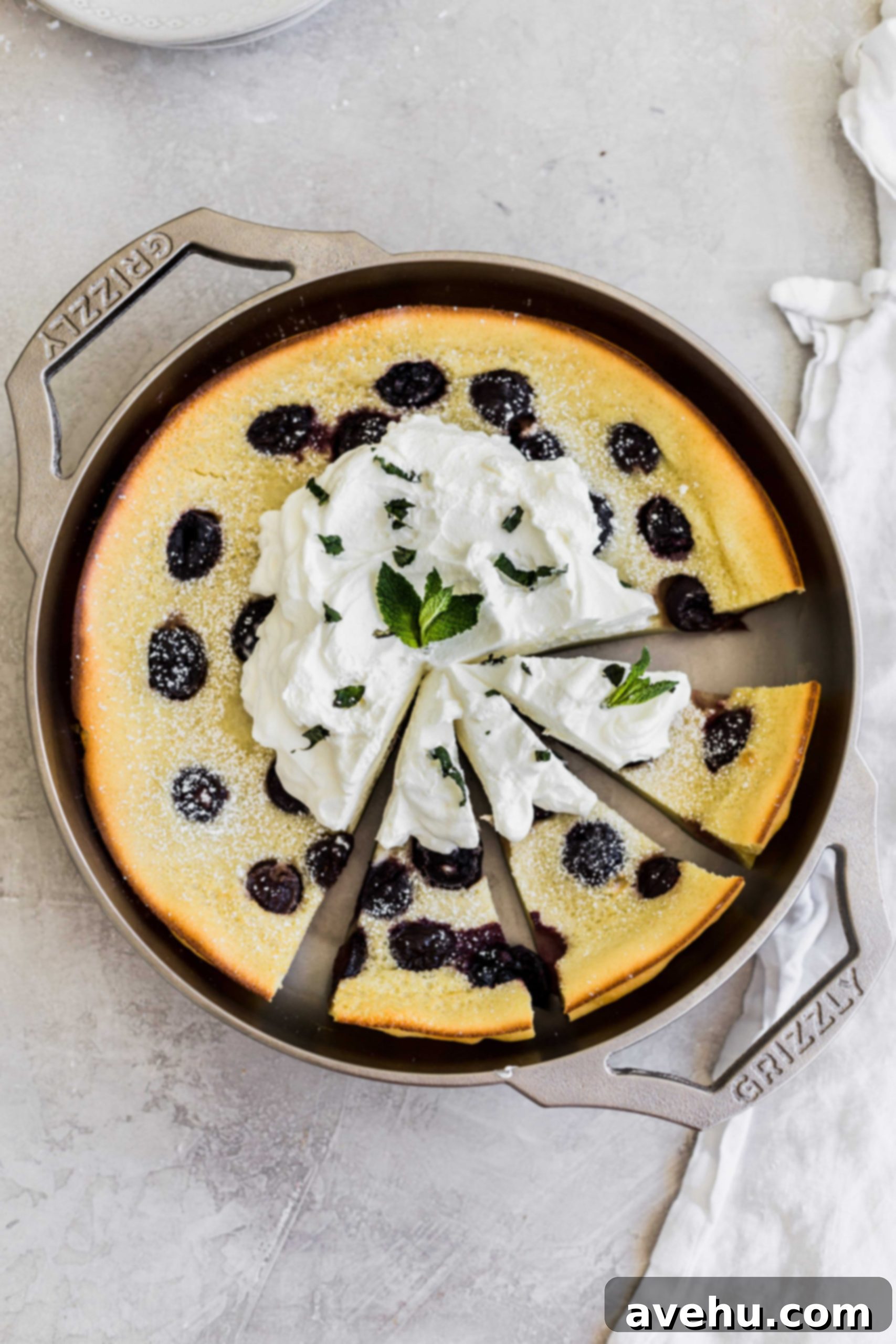 Bourbon Cherry Clafoutis 8 Three slices cut out but still left in the pan, of a cherry clafoutis made in a GRIZZLY nickel plated cast iron pan