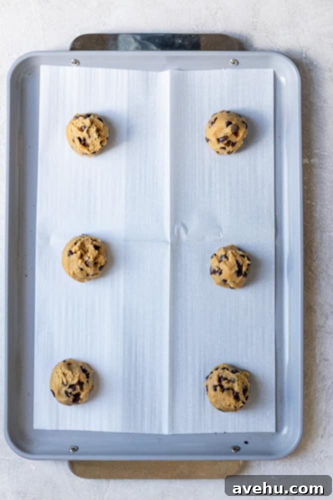 Speedy Six Chocolate Chip Cookies 5 6 cookie dough balls on a parchment lined cookie sheet.