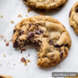 A chocolate chip cookie with a bite taken out of it.