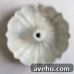 Luscious Strawberry Bundt Cake 6 A bundt pan, meticulously coated with a heavy layer of baking spray, rests on a light gray surface, prepared for perfect cake release.