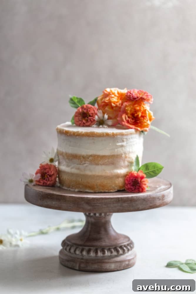 Your Guide to Stunning Floral Naked Cakes 2 A naked cake with flowers on a wooden cake stand, exuding rustic elegance.