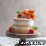 Your Guide to Stunning Floral Naked Cakes 7 A naked cake with flowers on a wooden cake stand.