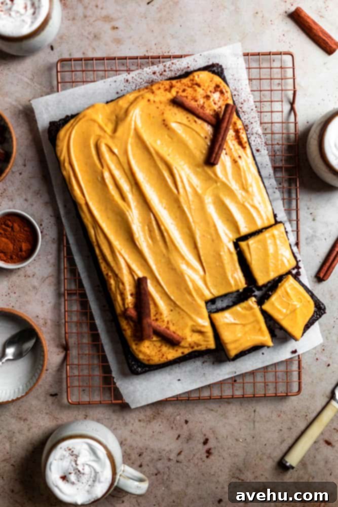Decadent Chocolate Pumpkin Sheet Cake 2 Chocolate pumpkin sheet cake sliced into squares on a piece of parchment paper, showcasing its moist texture and creamy frosting.