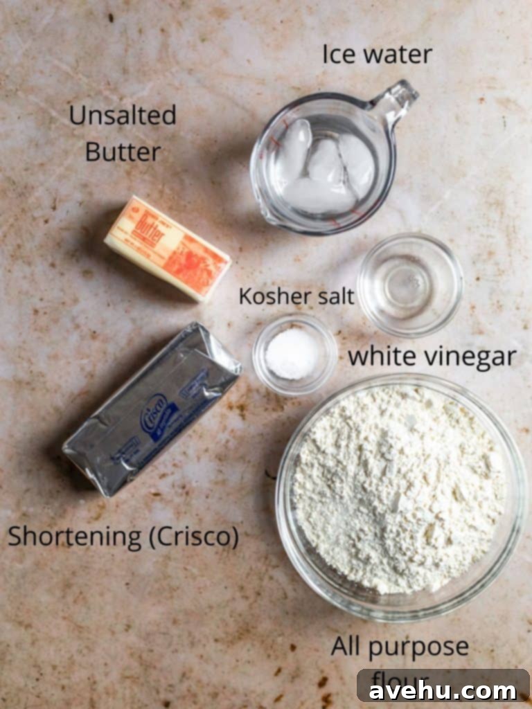 Layers of Perfection: Flaky Pie Crust 3 A selection of high-quality ingredients for a flaky pie crust, including flour, cold butter, shortening, salt, ice water, and white vinegar, neatly arranged.