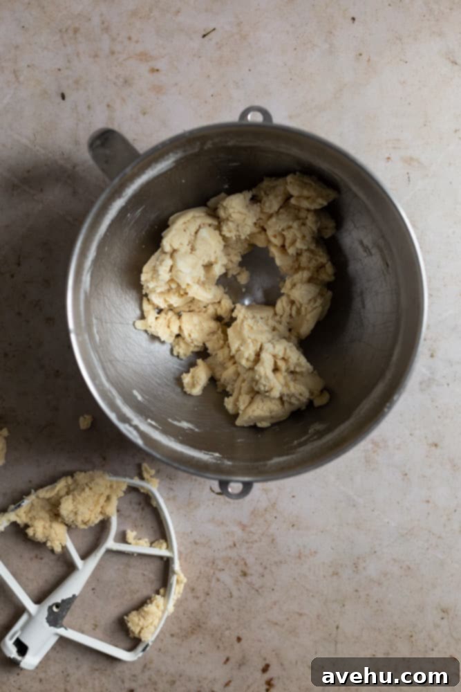 Layers of Perfection: Flaky Pie Crust 6 Pie dough crumbles clinging together in a metal bowl, showing the ideal consistency before light kneading, with visible flecks of fat.