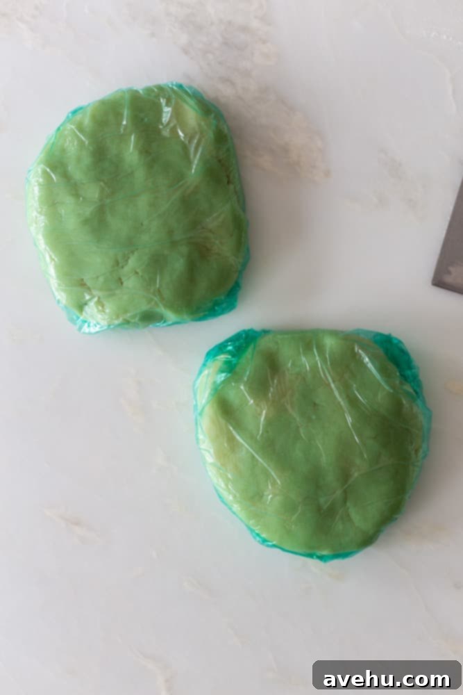 Layers of Perfection: Flaky Pie Crust 10 Two neatly formed discs of pie dough, securely wrapped in plastic wrap, indicating they are prepared for chilling in the refrigerator.