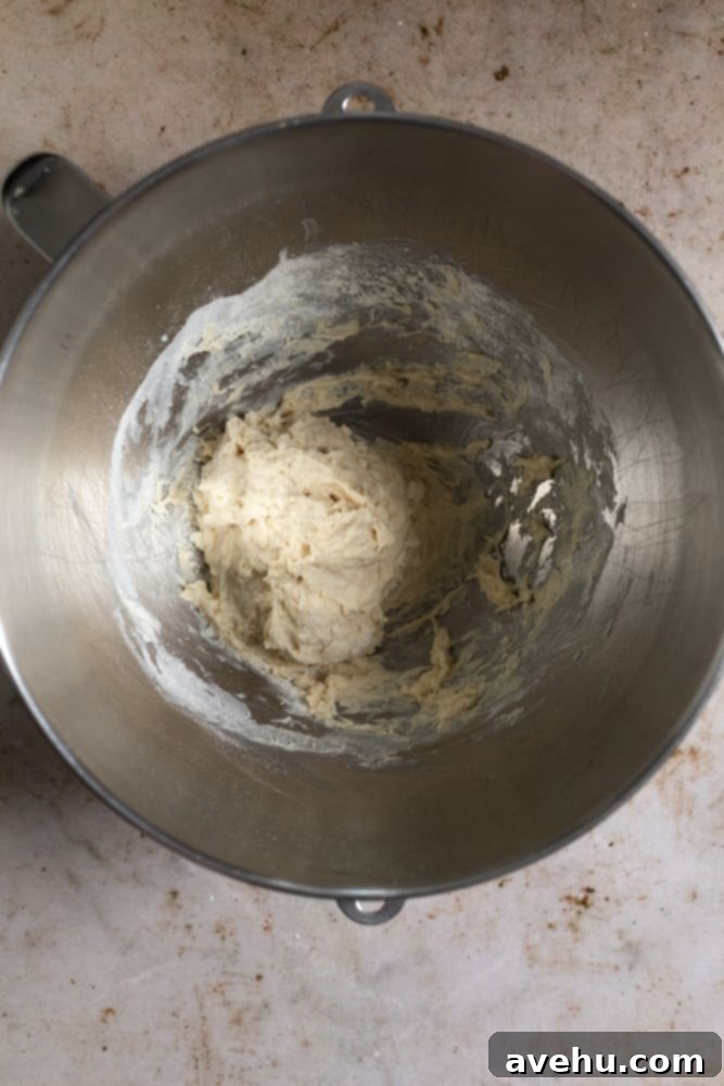 Homemade Challah Perfection 4 Challah dough mixture in a stand mixer bowl before the first rise, showing a sticky, shaggy texture.