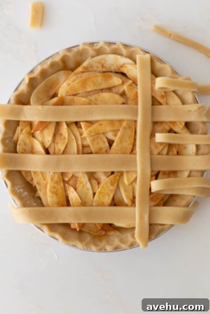 Sweet & Simple Caramel Apple Lattice Pie 11 The initial stage of weaving a lattice crust, with a vertical strip placed over three horizontal strips and under the peeled-back ones.
