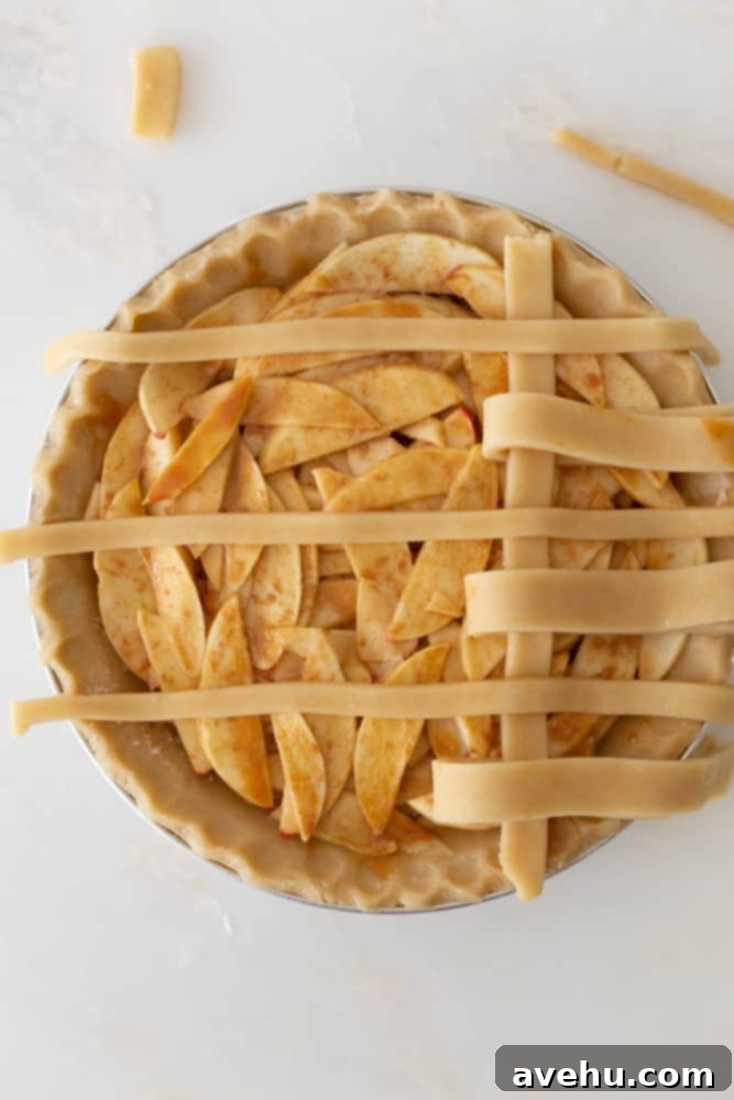 Sweet & Simple Caramel Apple Lattice Pie 13 Starting the second line of a lattice crust on an apple pie by peeling back the opposite set of horizontal strips.