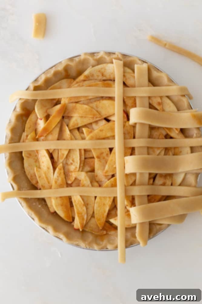 Sweet & Simple Caramel Apple Lattice Pie 14 Placing the second vertical strip over the horizontal strips that were not peeled back in the previous step, continuing the weave.