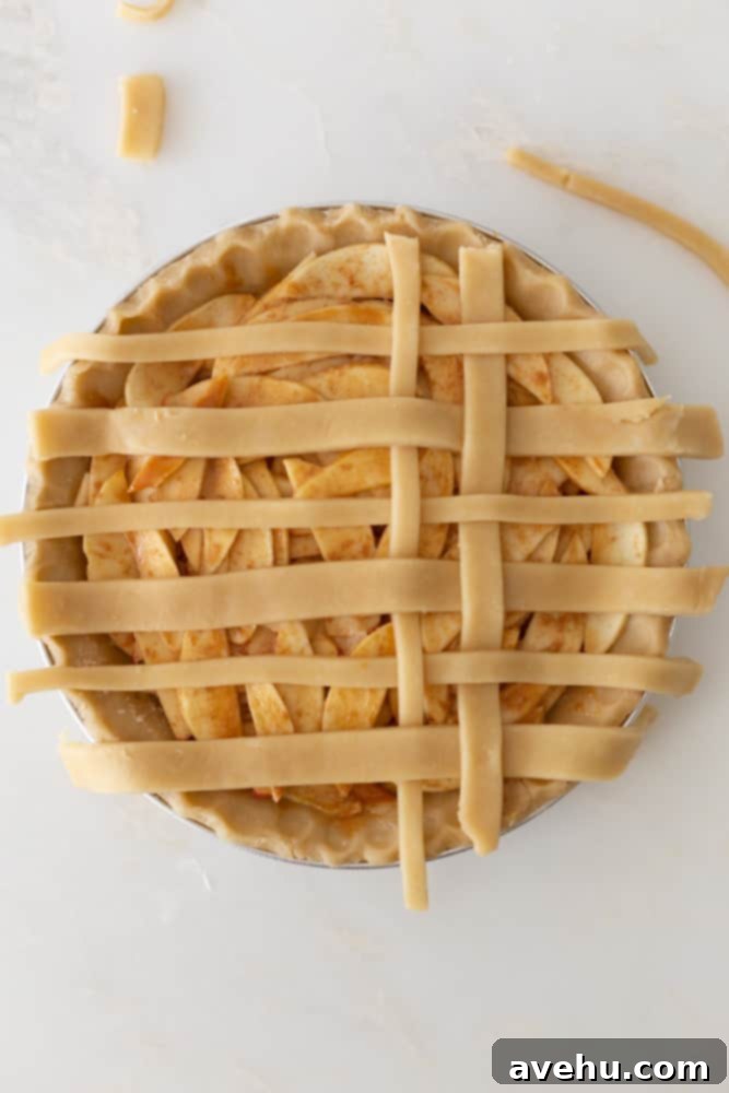 Sweet & Simple Caramel Apple Lattice Pie 15 The final step of folding over horizontal strips to complete a section of the lattice crust on a pie.