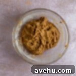 Gingerbread Biscotti with a Frosty Crunch 13 Finished batter for biscotti in a glass bowl on a pink background