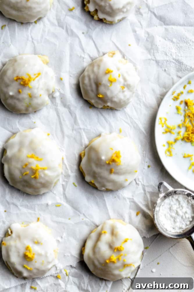 Cloud-Soft Italian Ricotta Cookies 2 Close-up on fluffy Italian ricotta cookies with vibrant lemon zest and colorful sprinkles, arranged beautifully next to a ceramic plate, highlighting their delicate glaze and soft texture.