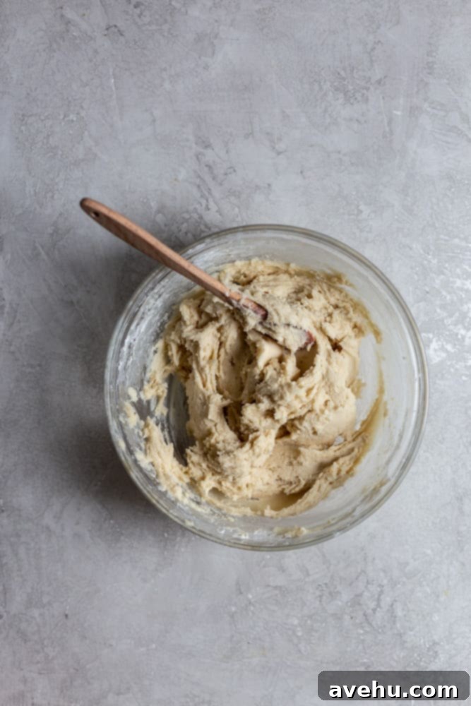 Creamy Raspberry Thumbprint Delights 5 Smooth cookie dough in a clear glass bowl, showcasing its perfect consistency before shaping.