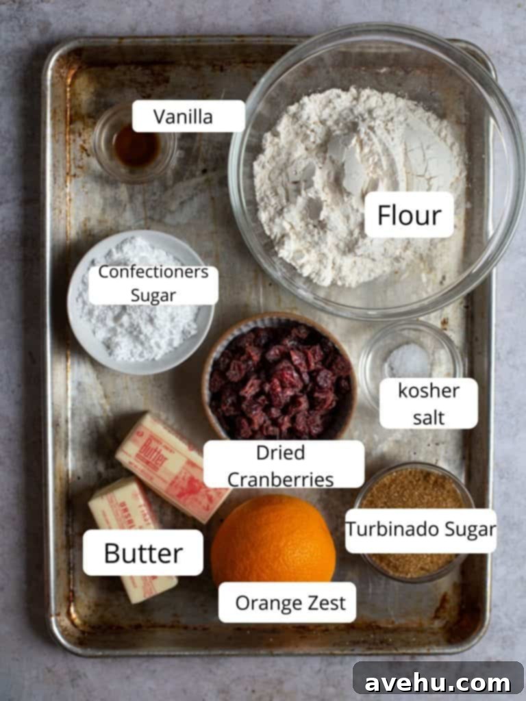 Cloudlike Cranberry Shortbread Delights 3 A selection of fresh and pantry ingredients including butter, sugar, flour, dried cranberries, and fresh oranges, laid out for making cranberry orange shortbread cookies.