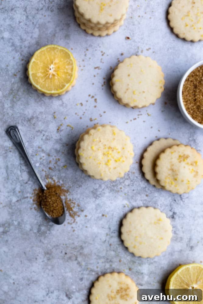 Cloud-Soft Lemon Shortbread 8 Lemon shortbread cookies stacked in piles on a blue gray surface, showcasing their delicious appearance