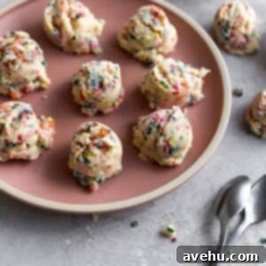 10-Minute Edible Sugar Cookie Dough Brown Sugar Free 2 Balls of edible sugar cookie dough on a pink plate, featuring colorful sprinkles and a smooth texture, ready to be enjoyed as a safe, no-bake treat.