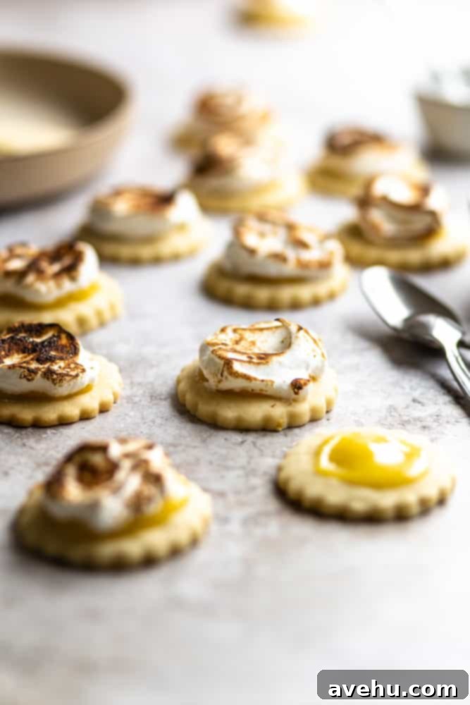 Zesty Lemon Curd Clouds 2 Closeup of a lemon meringue cookie with spoons in the background