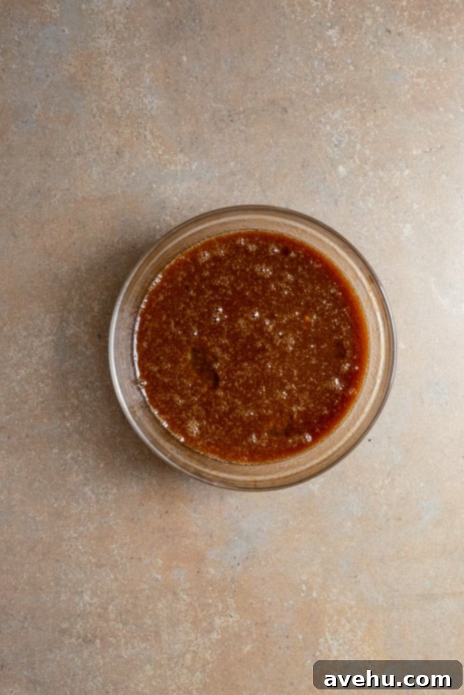 Foolproof Moist Carrot Bundt 5 Wet ingredients for carrot cake, including eggs, carrot baby food, and oil, mixed together in a clear glass bowl, ready to be combined with dry ingredients.