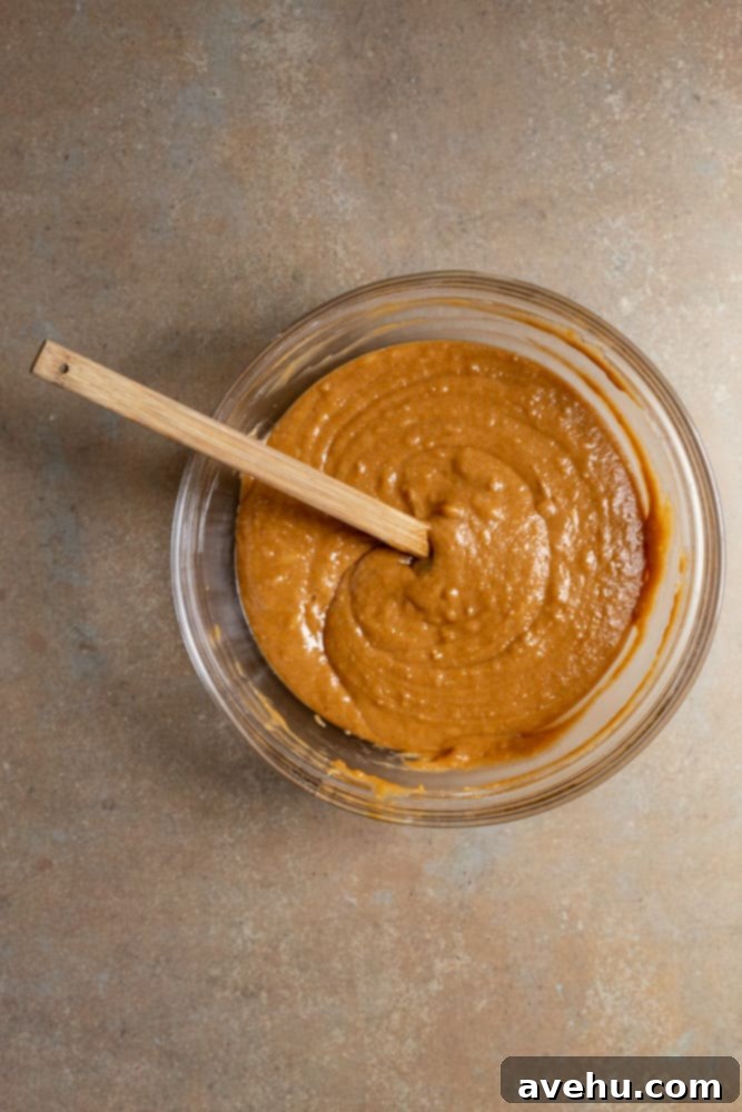 Foolproof Moist Carrot Bundt 6 The fully mixed carrot bundt cake batter in a large glass bowl, showing its smooth and thick consistency, ready to be poured into the bundt pan.