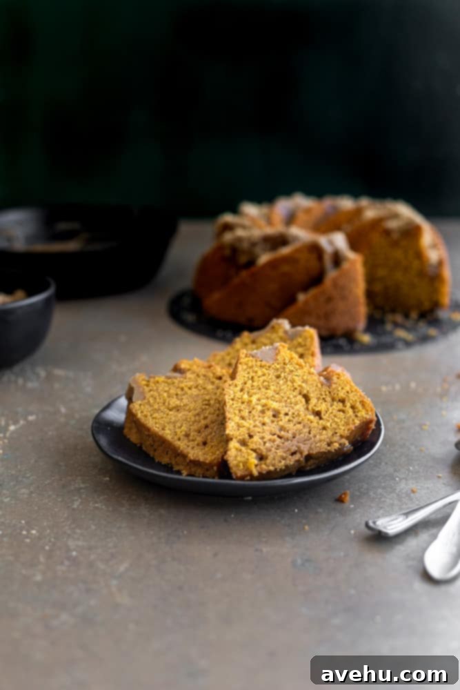Foolproof Moist Carrot Bundt 8 Two generous slices of carrot bundt cake, showing the moist crumb and the glistening brown sugar glaze, served on a black plate.