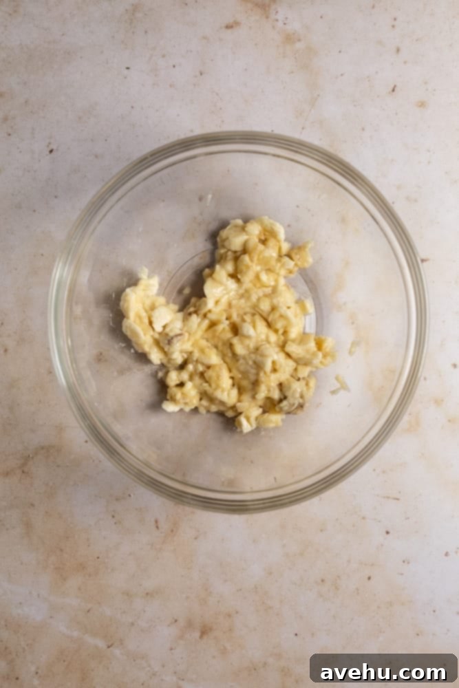 Deliciously Easy Banana Bundt Cake 3 Mashed up bananas in a glass bowl, ready for baking this moist bundt cake.