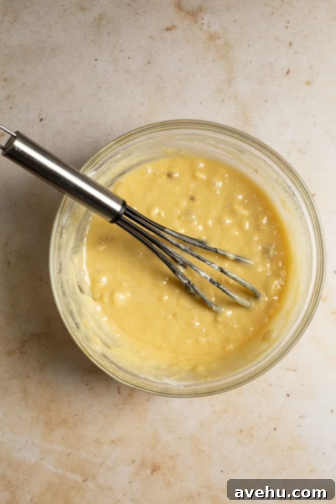 Deliciously Easy Banana Bundt Cake 4 Banana cake batter in a glass mixing bowl, perfectly mixed and ready to pour.