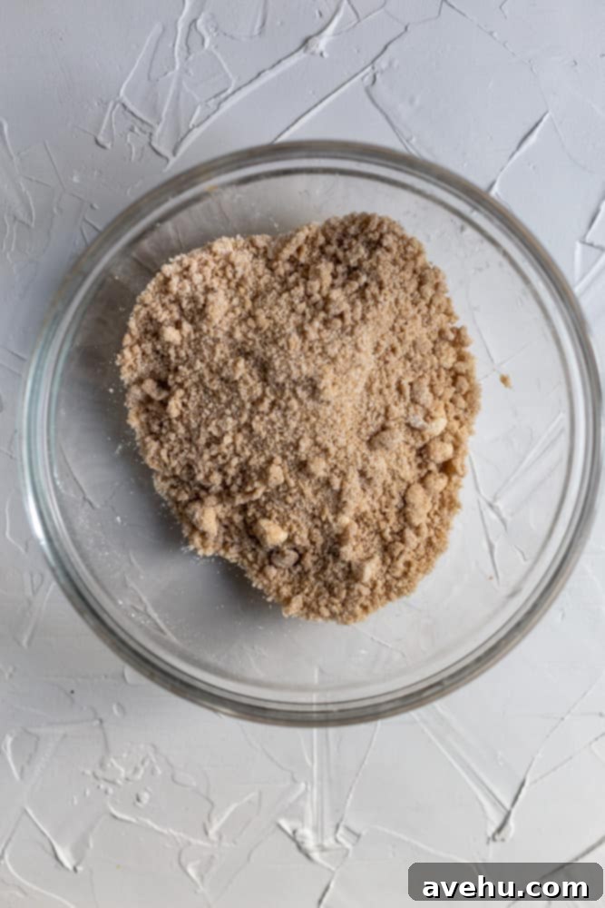 Easy Classic Streusel Crumbs Nut and Oat Free 5 Pre-baked streusel mixture in a glass bowl, showcasing the ideal coarse, wet sand texture with pea-sized clumps of butter