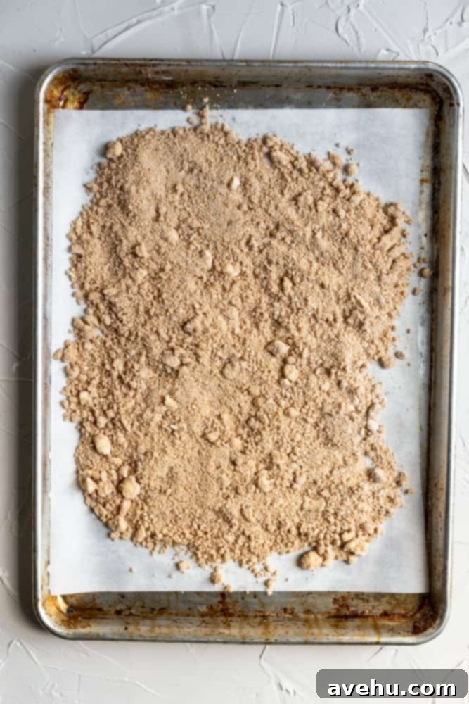 Easy Classic Streusel Crumbs Nut and Oat Free 6 Unbaked streusel spread out evenly on a parchment paper-lined sheet tray, ready for baking