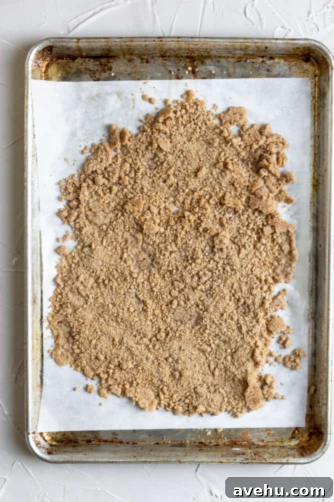 Easy Classic Streusel Crumbs Nut and Oat Free 7 Baked streusel cooling on parchment paper on a sheet tray after achieving a golden-brown and crunchy texture