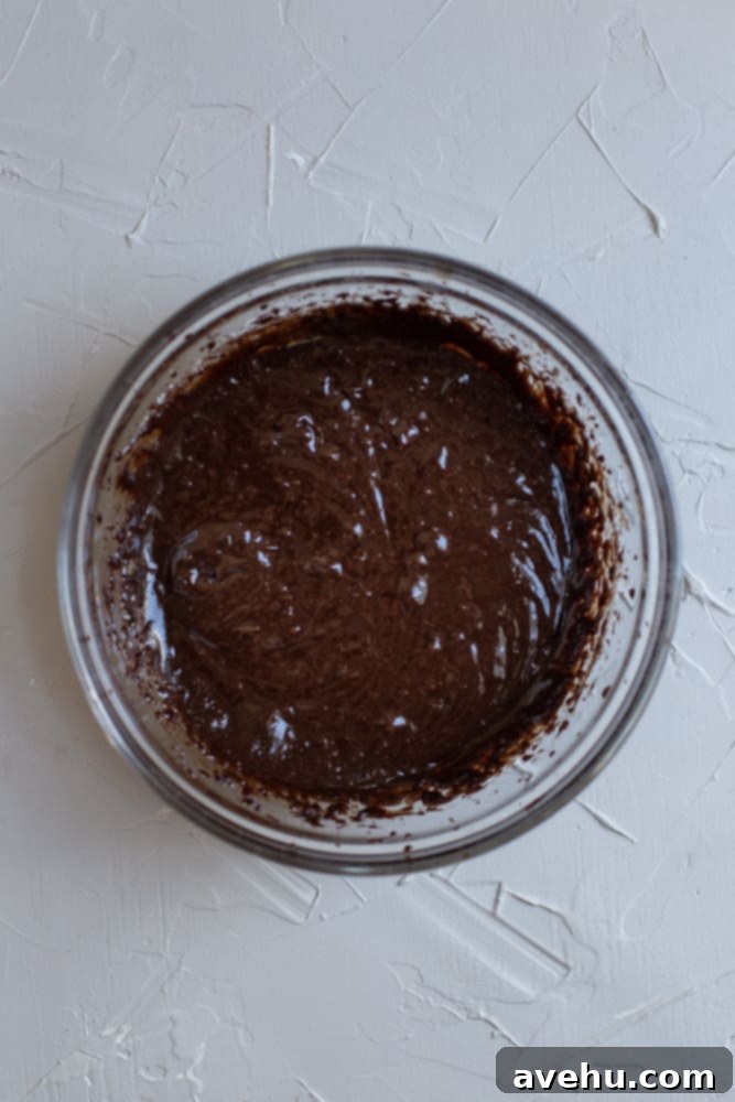 Decadent 30-Minute One-Bowl Fudgy Brownies 3 Light brown, airy brownie batter in a mixing bowl after being whipped, showing small air pockets