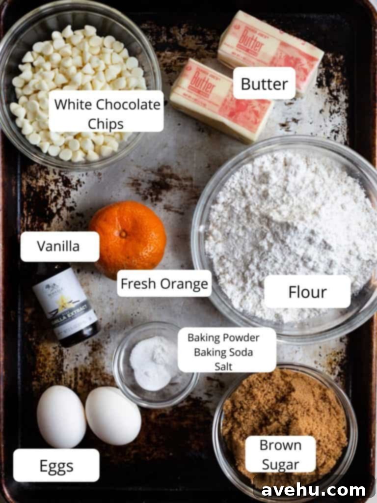 Zesty Orange Crunch-Chews 3 A collection of fresh ingredients laid out for making orange cookies, including oranges, butter, flour, sugar, and eggs.