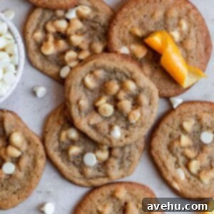 Zesty Orange Crunch-Chews 9 Crispy and chewy orange cookies with white chocolate chips on a gray surface, perfect for a creamsicle dessert.