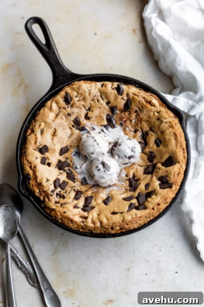 Ultimate Gooey Skillet Chocolate Chip Cookie 2 Skillet cookie topped with 3 scoops of vanilla ice cream and chocolate drizzle