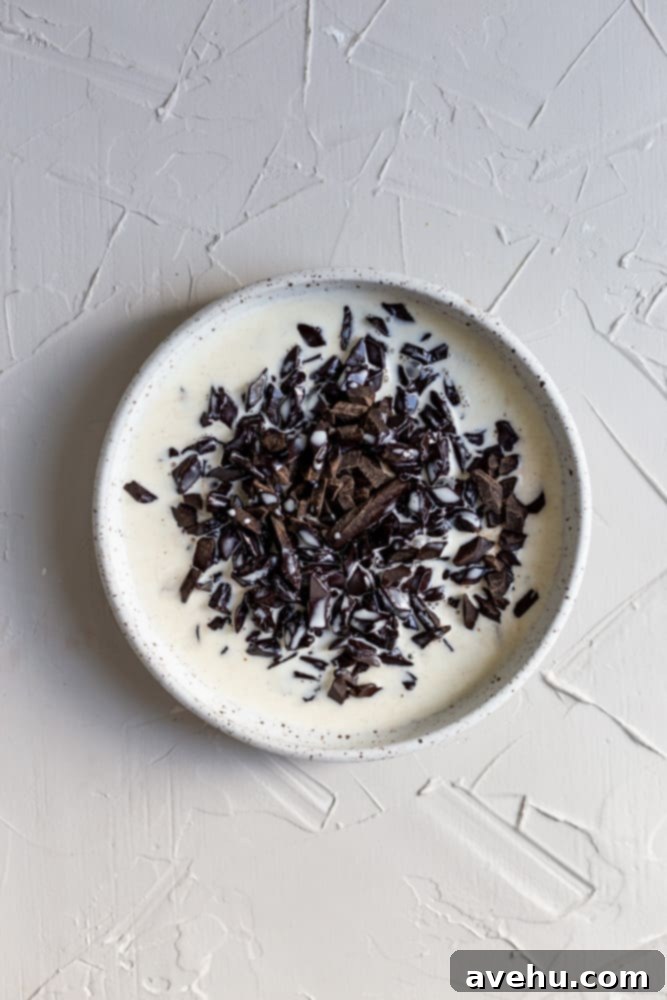 Quick Strawberry Fudge Brownies 7 Hot cream poured over semisweet chocolate pieces in a white bowl, beginning the ganache making process