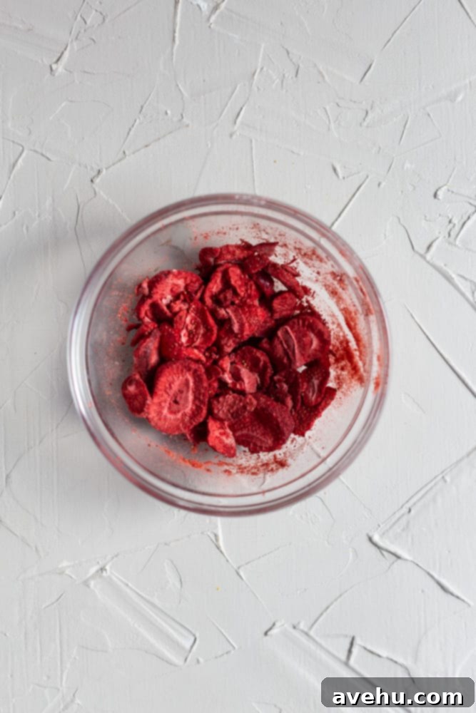 Decadent Strawberry Chewies 9 A small bowl filled with vibrant red freeze-dried strawberries, ready for processing.