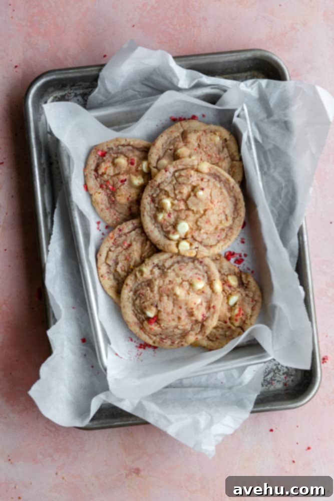 Decadent Strawberry Chewies 14 Multiple layers of freshly baked strawberry cookies, separated by parchment paper, stacked on trays on a charming pink surface.