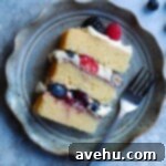 Lush Berry Chantilly Layers 13 A slice of berry chantilly cake on a ruffled plate