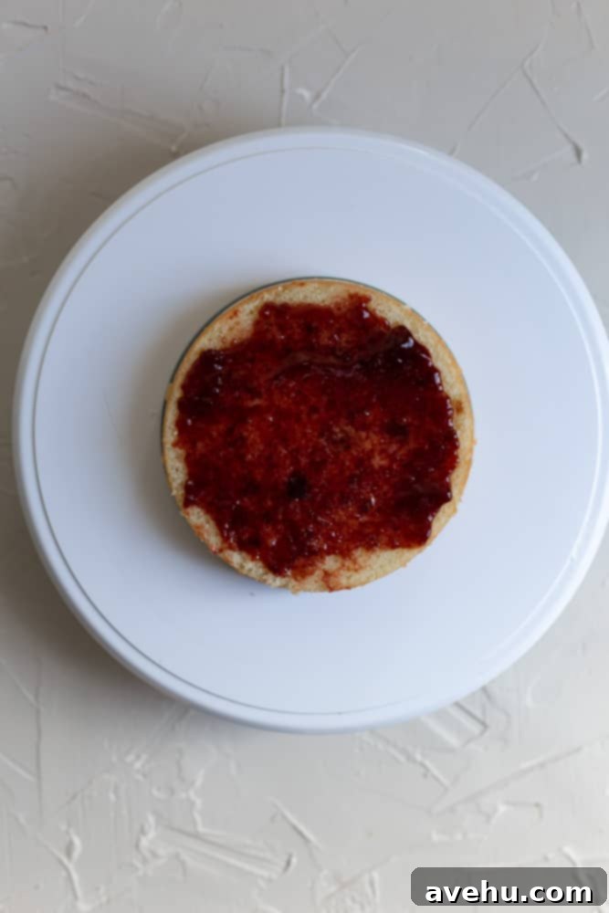 Lush Berry Chantilly Layers 5 A layer of strawberry jam spread on a cake layer