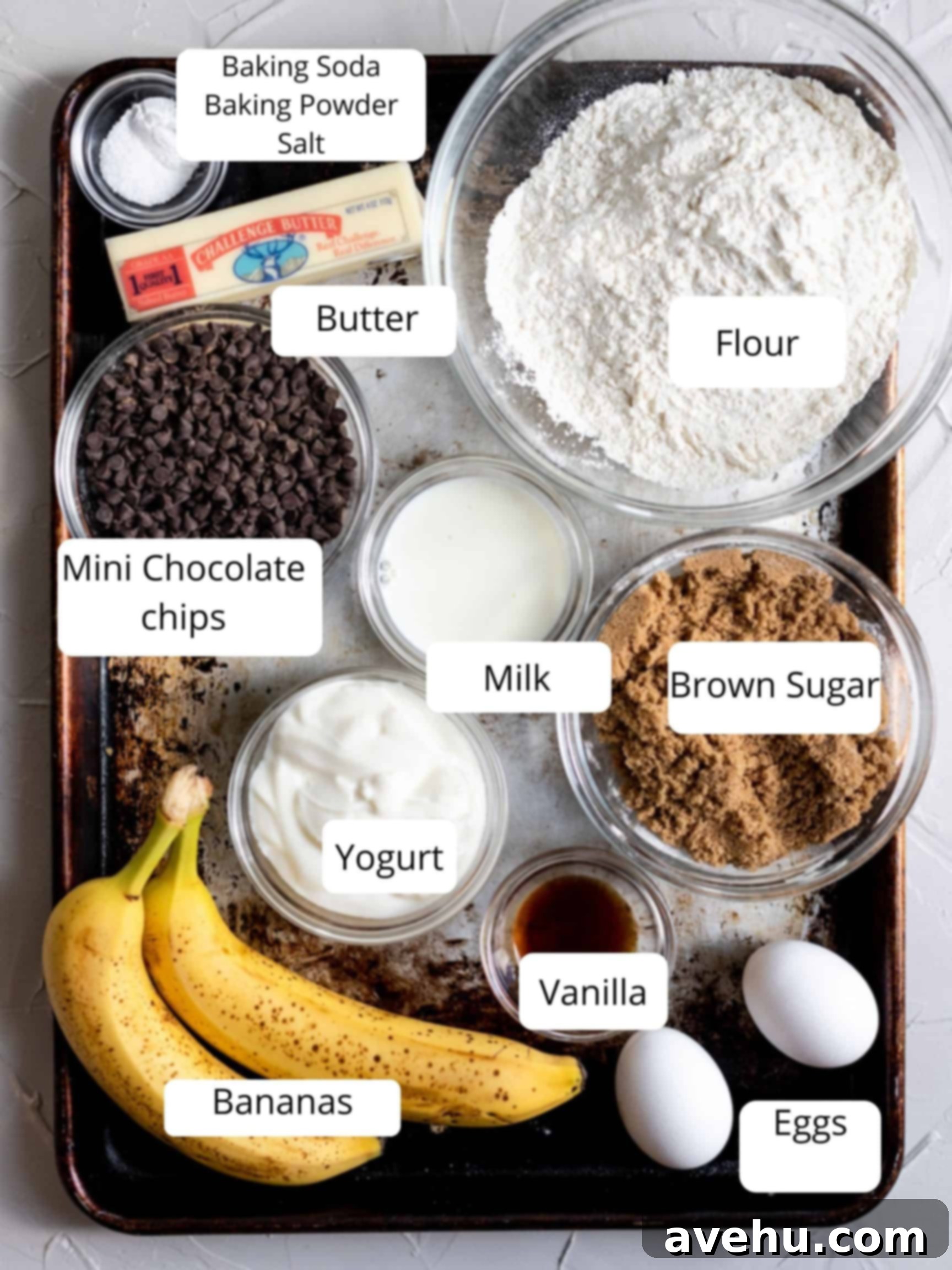 Simple and Scrumptious Banana Chocolate Chip Muffins 3 A selection of fresh ingredients laid out for making chocolate chip banana muffins, including ripe bananas, chocolate chips, flour, and yogurt.