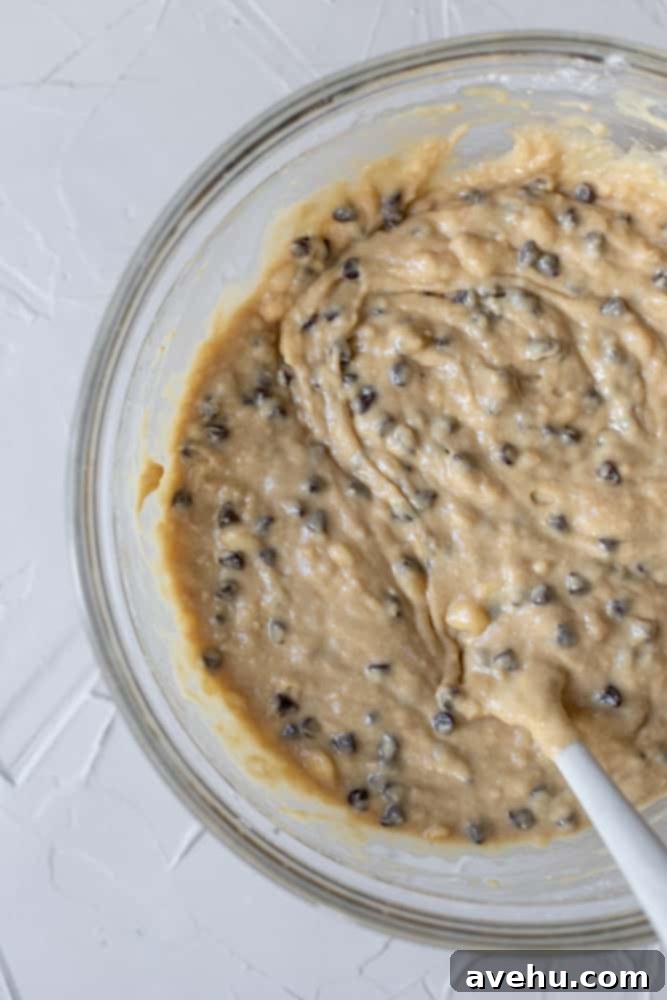 Simple and Scrumptious Banana Chocolate Chip Muffins 6 Finished batter for chocolate chip banana muffins in a glass bowl, with chocolate chips folded in.