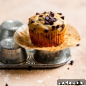 A chocolate chip banana muffin sitting on top of an overturned muffin pan