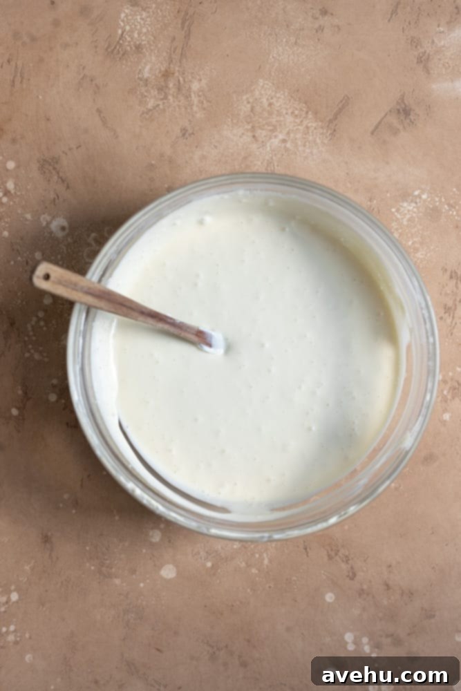 Irresistible Mini Cheesecake Treats 6 Cheesecake batter in a glass bowl on a beige surface