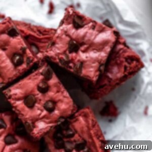 4 Red velvet brownies layered on top of each other on a piece of crinkled parchment paper