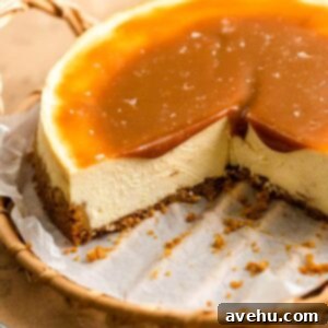 Salted Caramel Cheesecake 13 A cheesecake with a slices taken out of it on a wooden tray with caramel sauce on top.