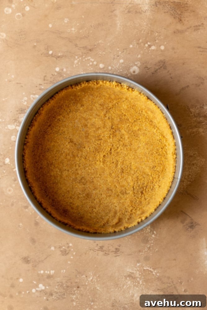 Salted Caramel Cheesecake 5 A perfectly pressed graham cracker crust lining the bottom and sides of a springform pan, ready for the cheesecake filling.