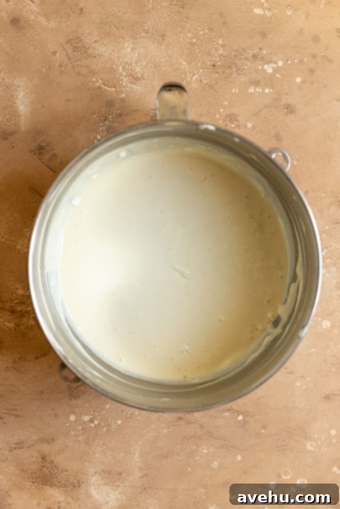 Salted Caramel Cheesecake 6 Smooth, creamy cheesecake batter filling a large mixing bowl, perfectly blended and ready for baking.