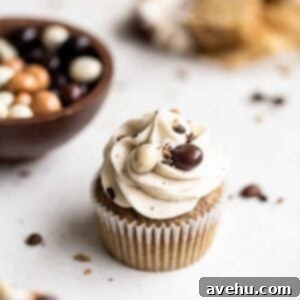 A cluster of delightful espresso cupcakes arranged on a pristine white surface, accompanied by a small bowl of glistening chocolate-covered espresso beans, ready for garnish.