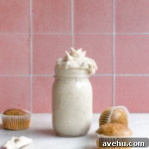 Espresso buttercream in a mason jar next to 3 unfrosted cupcakes